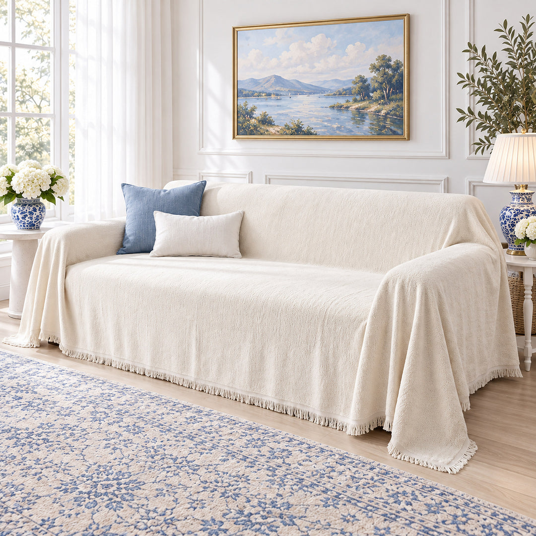 Cream sofa cover draped over a sofa in a bright living room with blue accents